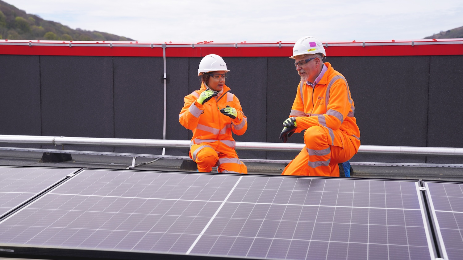 Amey staff looking at solar panels for sustainable estates story. Image: Amey